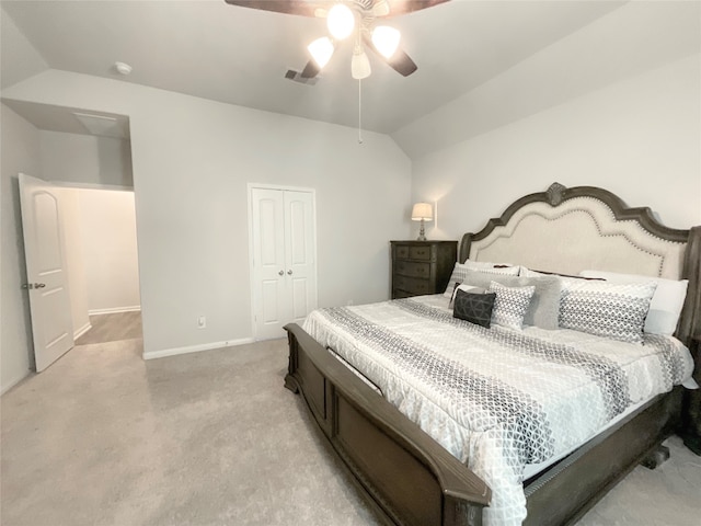 bedroom featuring lofted ceiling, ceiling fan, a closet, and light colored carpet