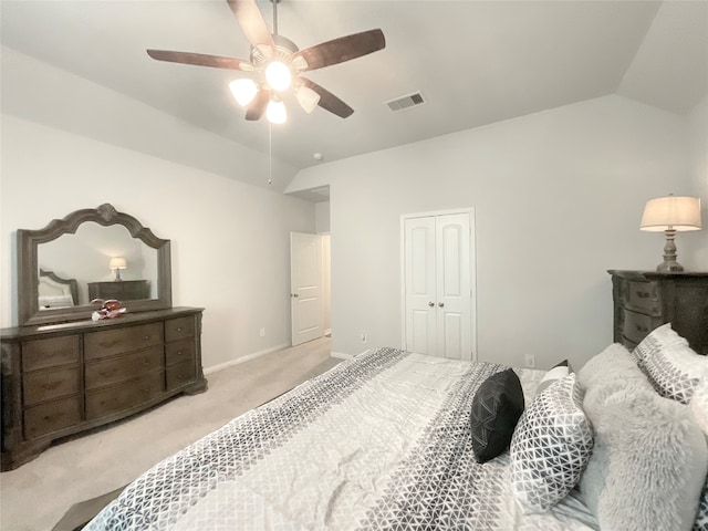 carpeted bedroom featuring ceiling fan, lofted ceiling, and a closet