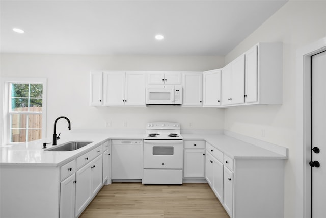 kitchen featuring white cabinetry, light wood-type flooring, white appliances, and sink