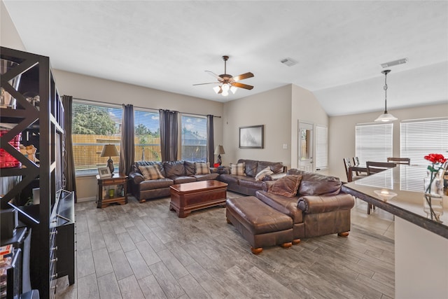 living room featuring hardwood / wood-style floors, vaulted ceiling, and ceiling fan