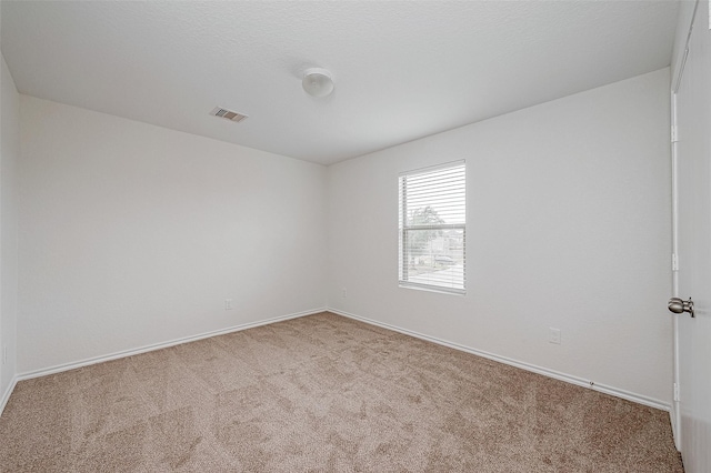 unfurnished room featuring carpet and a textured ceiling