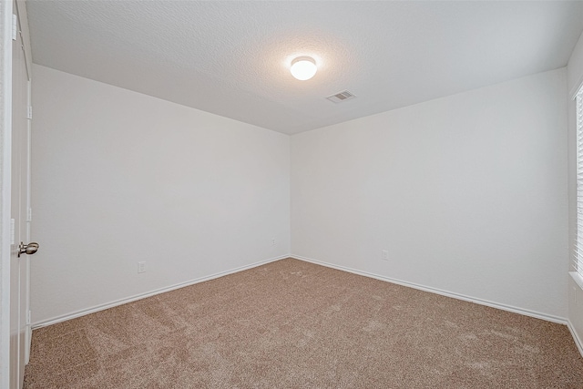 carpeted spare room featuring a textured ceiling