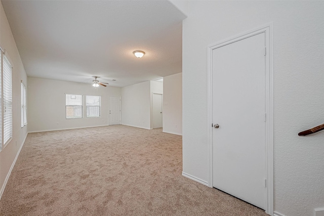 carpeted empty room featuring ceiling fan