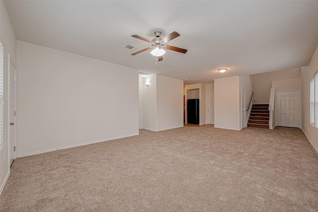 spare room featuring light colored carpet and ceiling fan