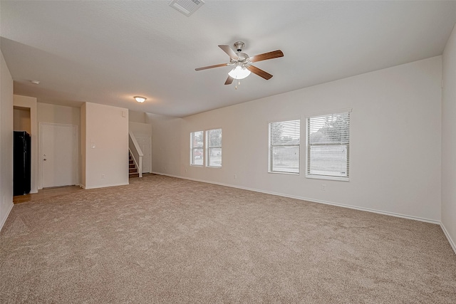 empty room featuring light colored carpet and ceiling fan