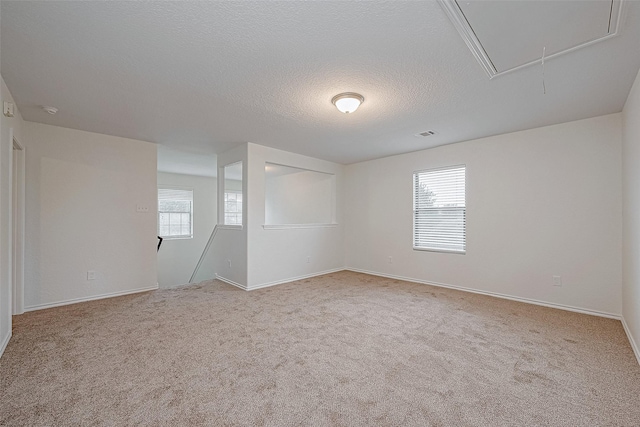 carpeted empty room with a textured ceiling