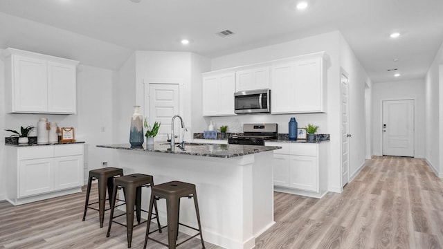 kitchen featuring white cabinetry, a center island with sink, and appliances with stainless steel finishes