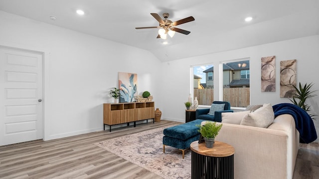 living room featuring ceiling fan, vaulted ceiling, and light wood-type flooring