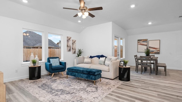 living room with light wood-type flooring, vaulted ceiling, and ceiling fan