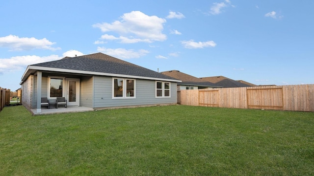 rear view of house featuring a lawn and a patio area