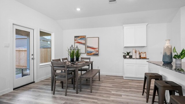 dining area featuring lofted ceiling, french doors, and light hardwood / wood-style flooring