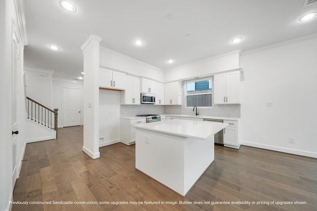 kitchen with decorative backsplash, a center island, stainless steel appliances, white cabinets, and dark wood-type flooring