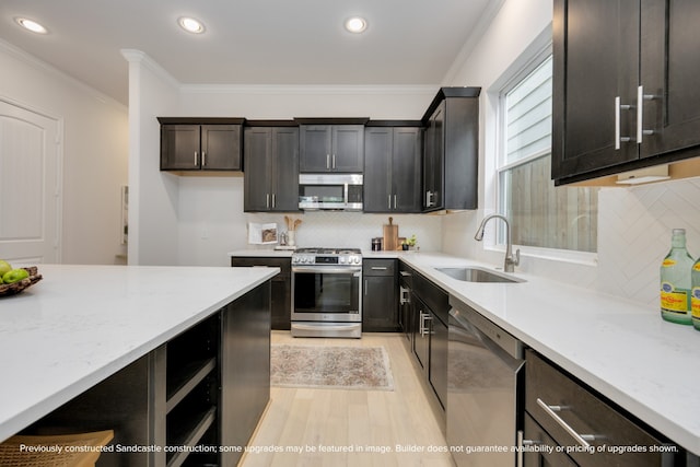 kitchen with light stone counters, sink, appliances with stainless steel finishes, crown molding, and decorative backsplash