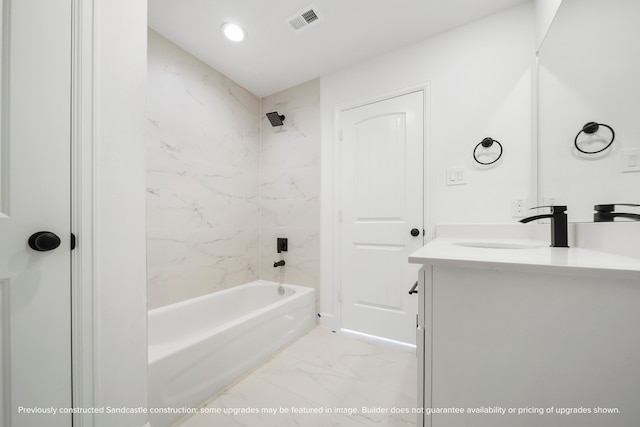 bathroom with tiled shower / bath and vanity