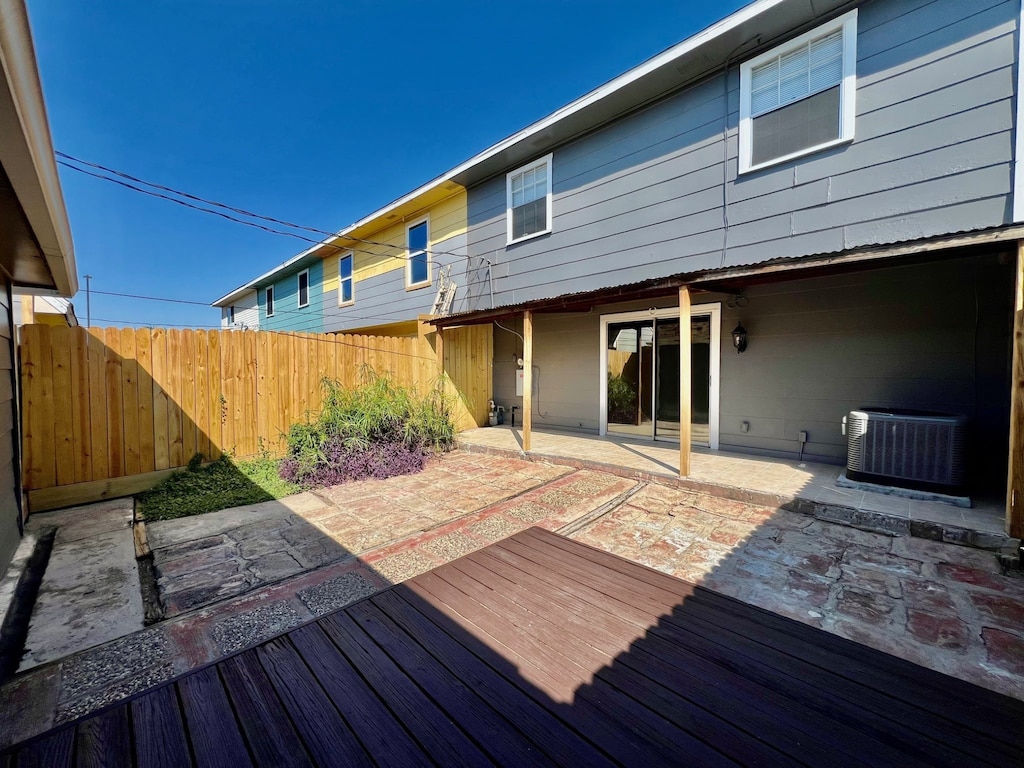 wooden deck with central AC unit and a patio