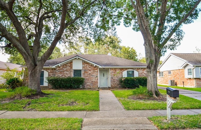 single story home with central AC unit and a front yard