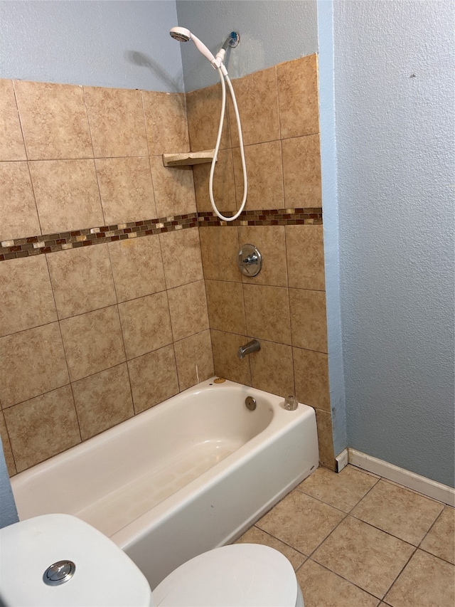 bathroom featuring tiled shower / bath combo, toilet, and tile patterned floors