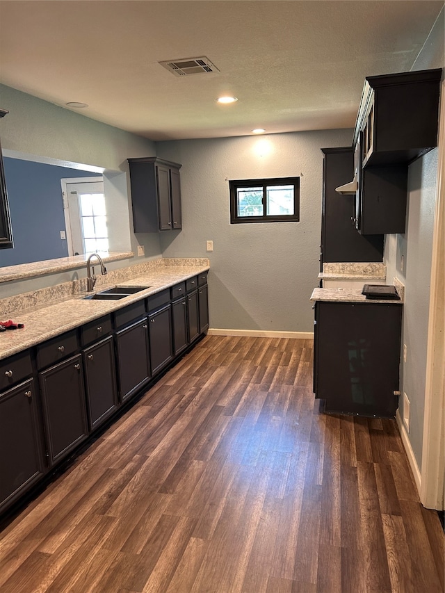 kitchen featuring light stone countertops, sink, and dark hardwood / wood-style flooring