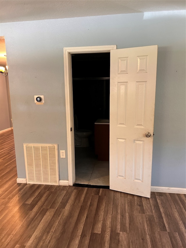 unfurnished bedroom with dark wood-type flooring