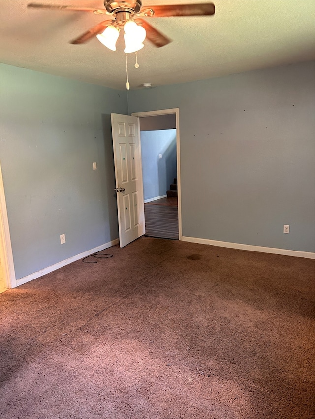 spare room featuring ceiling fan, a textured ceiling, and carpet