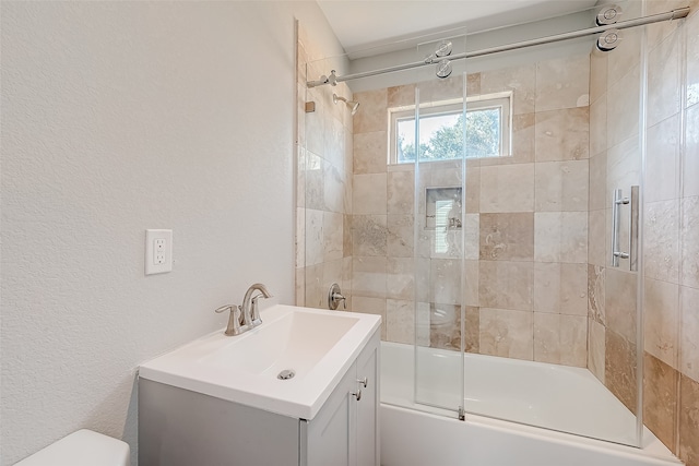 full bathroom with enclosed tub / shower combo, vanity, and toilet