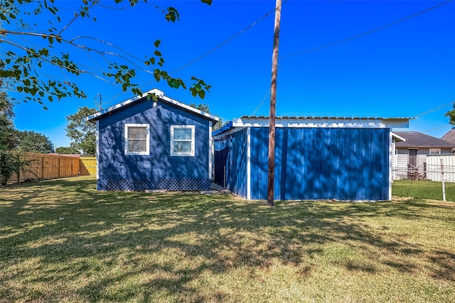 back of property featuring a yard and an outbuilding