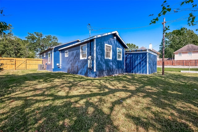 rear view of house featuring a yard and central AC