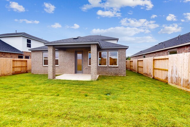 rear view of property featuring a patio area and a yard