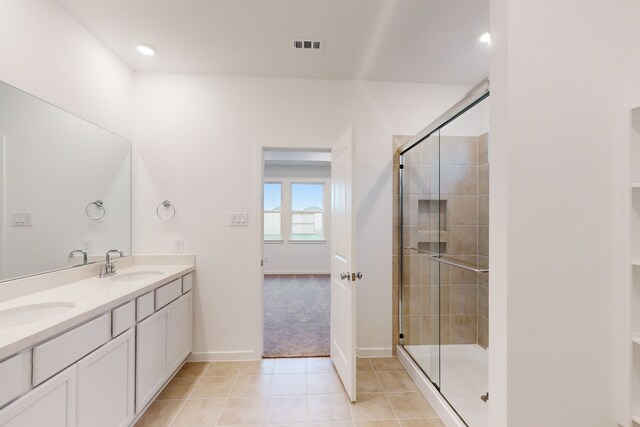 bathroom with vanity, walk in shower, and tile patterned flooring