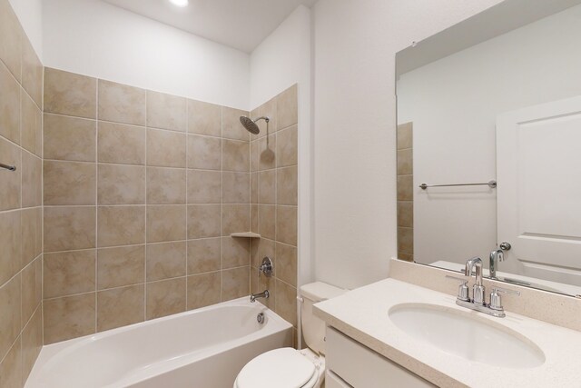 full bathroom featuring vanity, tiled shower / bath combo, and toilet