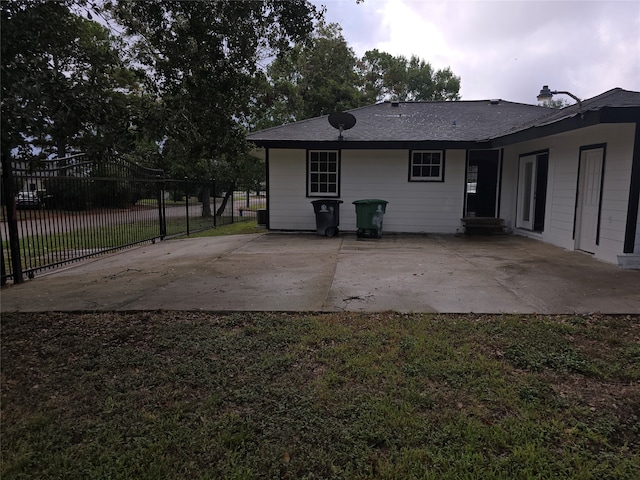 back of property with a lawn and a patio