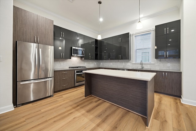 kitchen featuring stainless steel appliances, light hardwood / wood-style floors, a center island, sink, and pendant lighting