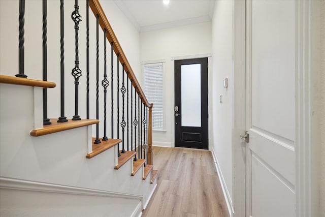 entryway with light hardwood / wood-style floors and crown molding