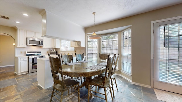 dining area with a textured ceiling and a wealth of natural light