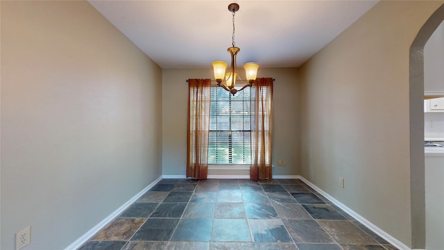 unfurnished dining area with an inviting chandelier