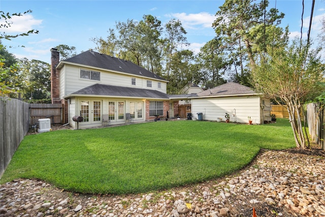 back of house featuring french doors and a lawn