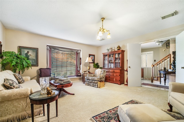 carpeted living room featuring a chandelier and a textured ceiling