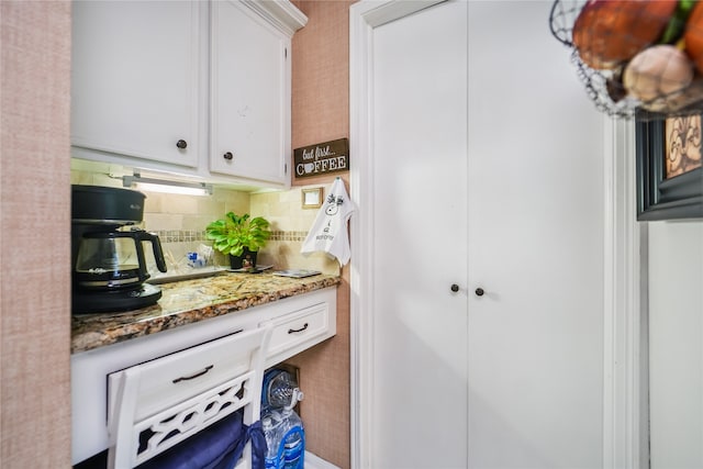 kitchen featuring stone counters, decorative backsplash, and white cabinets