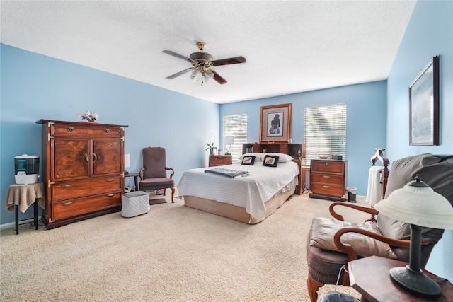 carpeted bedroom featuring a textured ceiling and ceiling fan