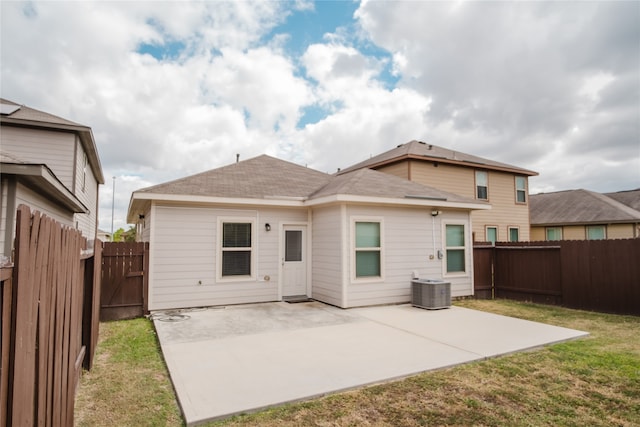 rear view of property featuring a patio, central AC, and a lawn