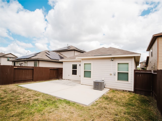 rear view of property with central AC, a patio, and a lawn