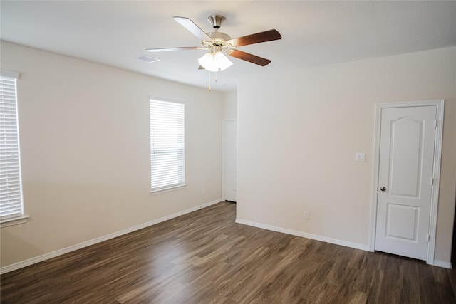 spare room featuring dark wood-type flooring and ceiling fan