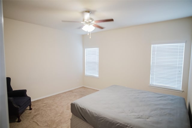 bedroom with multiple windows, light carpet, and ceiling fan