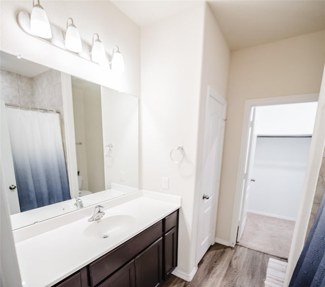 bathroom with wood-type flooring, toilet, and vanity