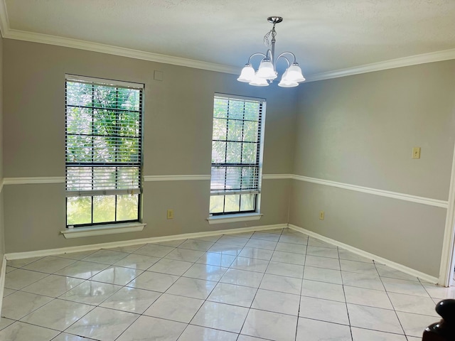 tiled spare room featuring ornamental molding and a chandelier