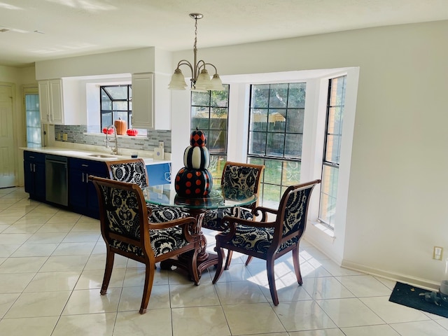 dining space featuring sink, light tile patterned floors, and a chandelier