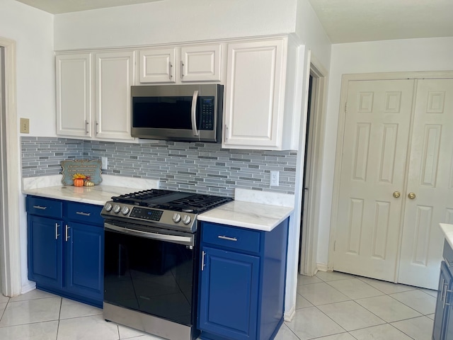 kitchen featuring appliances with stainless steel finishes, blue cabinets, and white cabinets