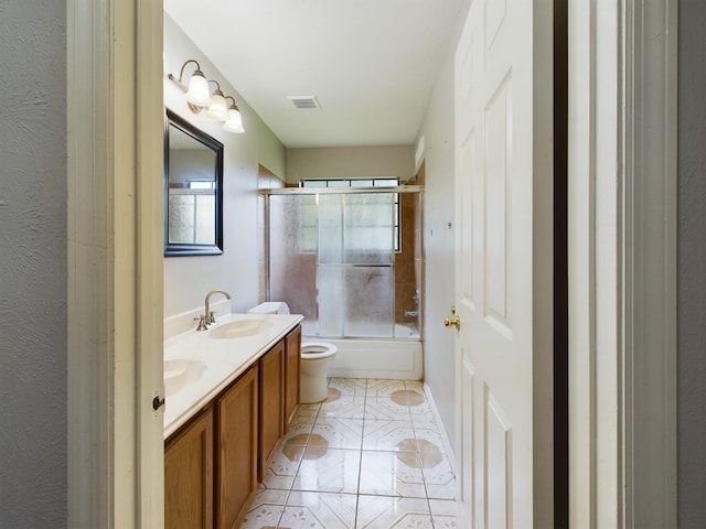 full bathroom with vanity, enclosed tub / shower combo, toilet, and tile patterned floors