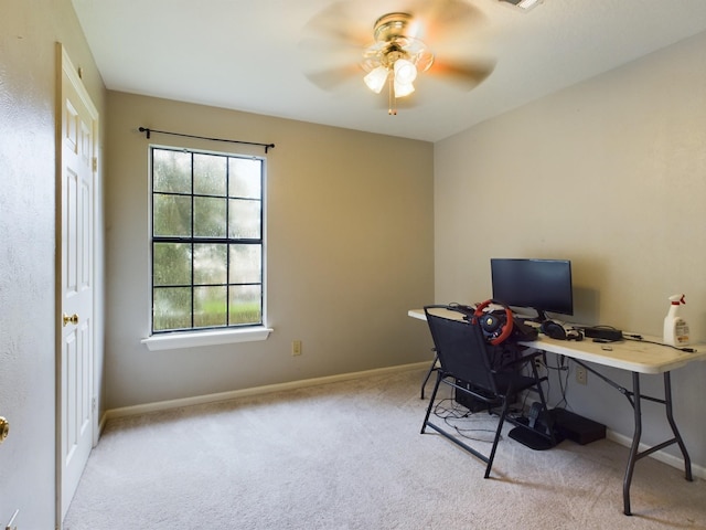 carpeted home office featuring ceiling fan