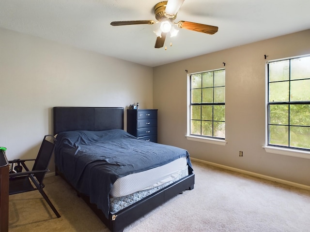 bedroom with ceiling fan, carpet, and multiple windows